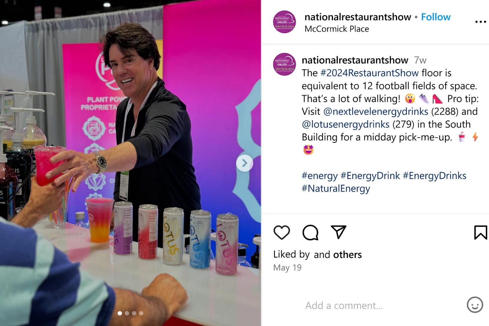 Man at a booth at the National Restaurant Show hands a pink drink to a person.