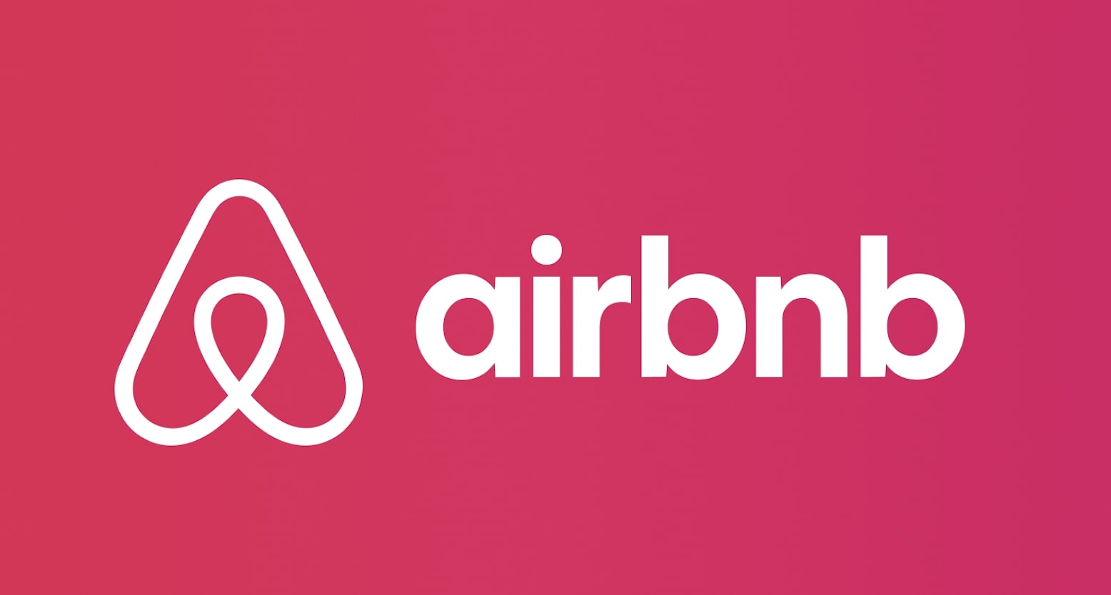 Airbnb's white logo on a pink background
