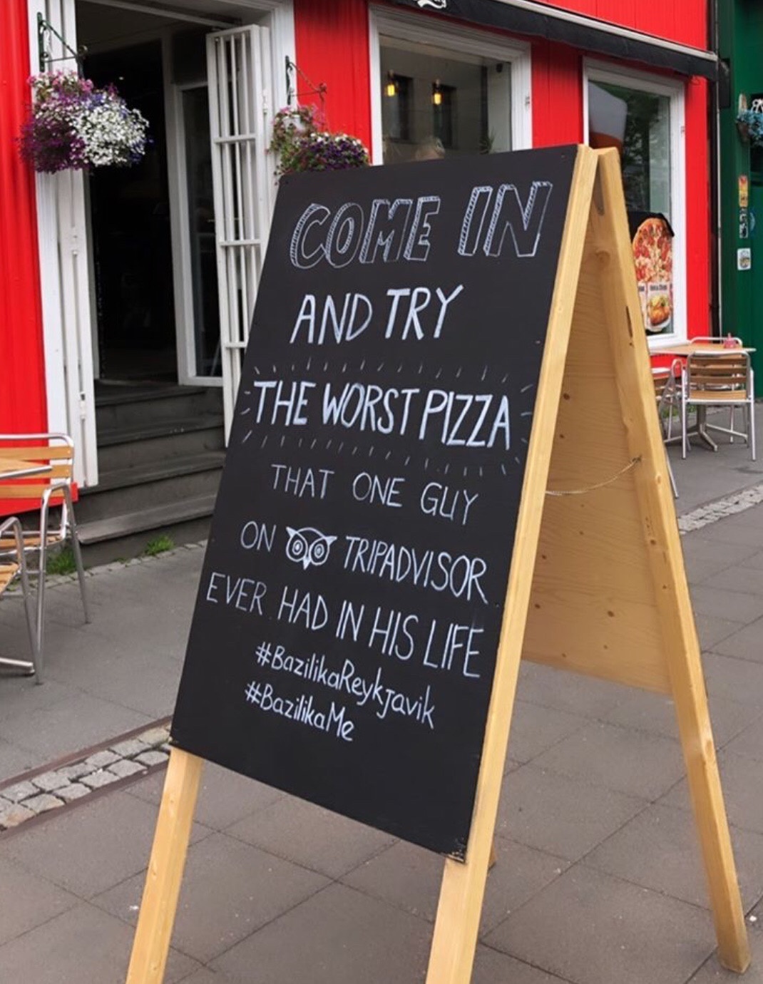A restaurant sign with "Come in and try the worst pizza that one guy on Tripadvisor ever had in his life" copy