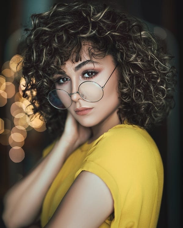 A woman wearing glasses and yellow top image from Pexels