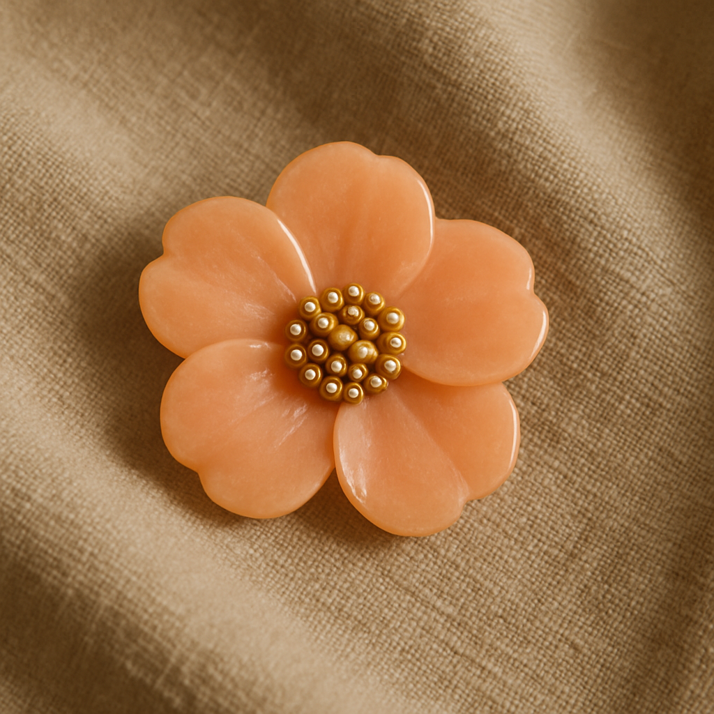 Peach-colored brooch on fabric